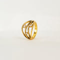 Gold ring with diamond accents on a light beige background