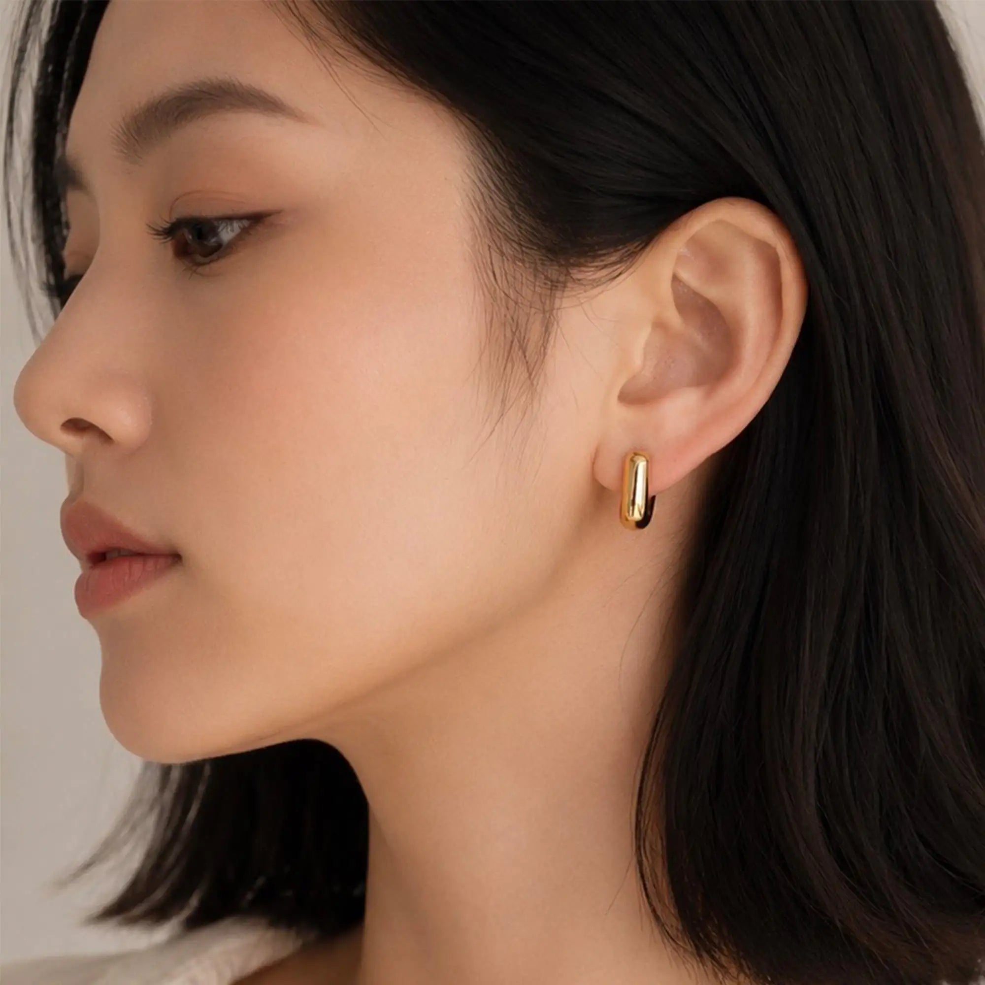 Solène Huggie Earrings gold sculptural close-up stainless steel — Tamola Jewellery
